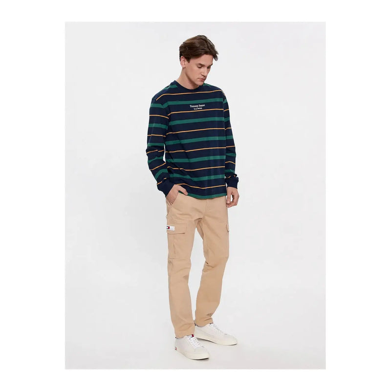 Tommy Jeans men beige cotton elastane trousers paired with a navy and teal striped long-sleeve crewneck sweatshirt