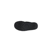 Back side of ugg women black suede leather slippers showing black rubber sole with starburst tread pattern and logo embossed near heel