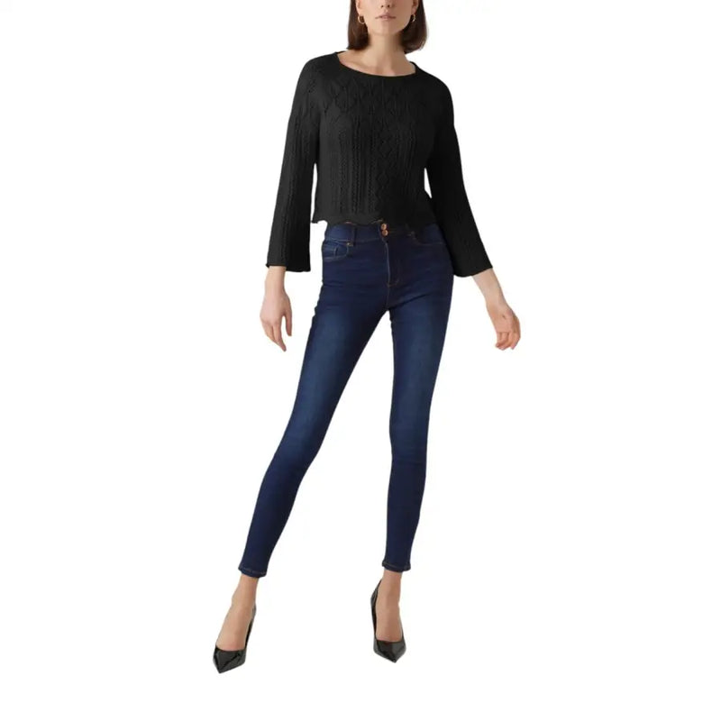 A pair of dark indigo cotton acrylic skinny jeans with five-pocket design and subtle fading at the thighs