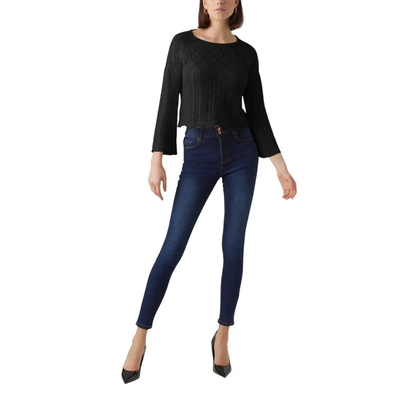A pair of dark indigo cotton acrylic skinny jeans with five-pocket design and subtle fading at the thighs