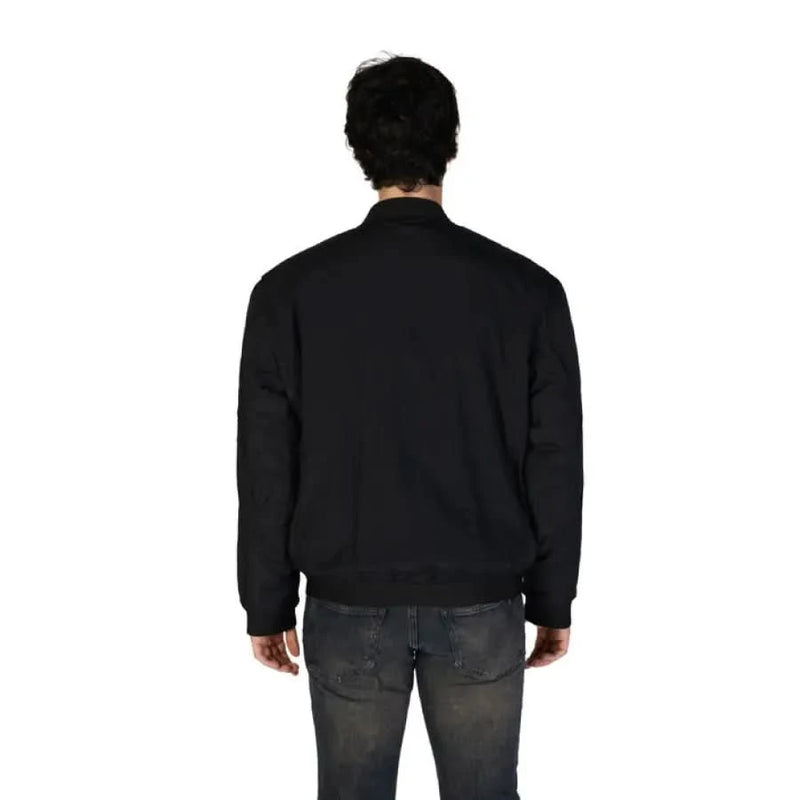 Back view of a model in a Boss Men’s Black Mandarin Jacket and faded jeans