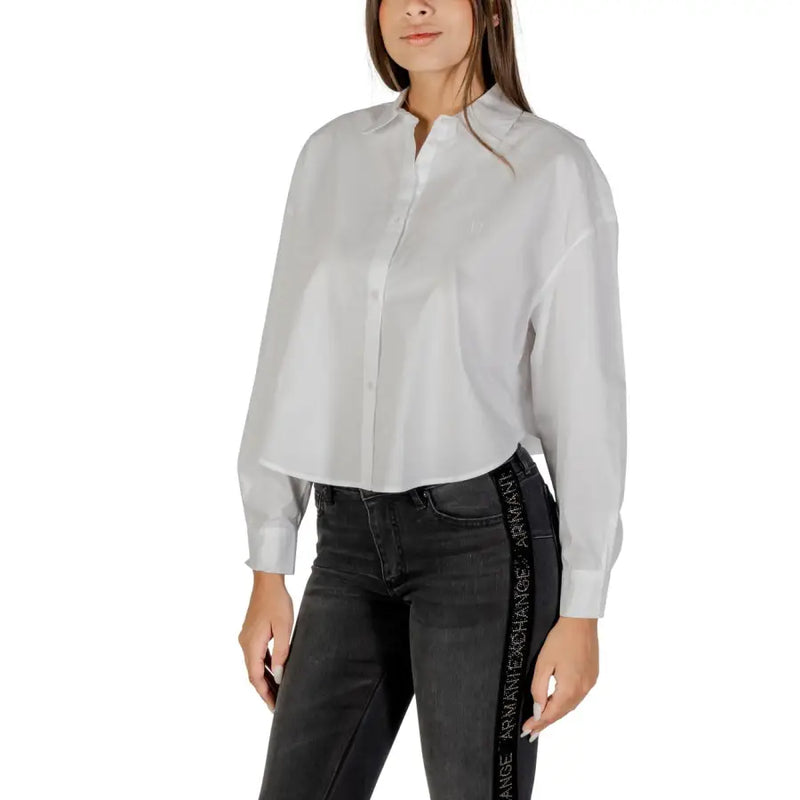 White cotton long-sleeve button-up shirt with a branded side stripe and dark-wash jeans