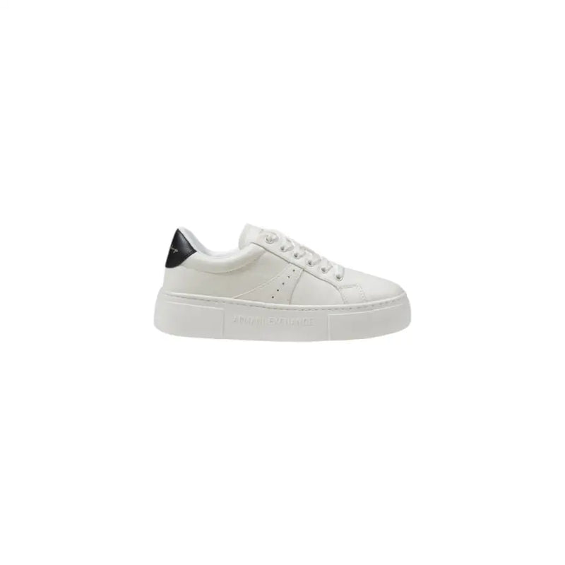 White leather low-top sneaker with black heel accent and embossed branding on the sole shown from the back side