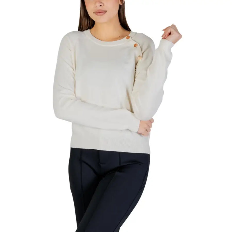 Cream-colored long sleeve round neck knit top for women featuring wooden buttons along the shoulder seam