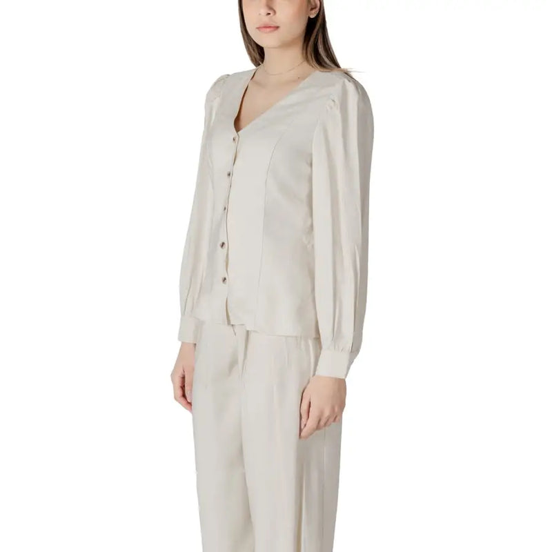 A soft cream-colored viscose blouse for women featuring long sleeves, v-neck, button-up front, and subtle pleats