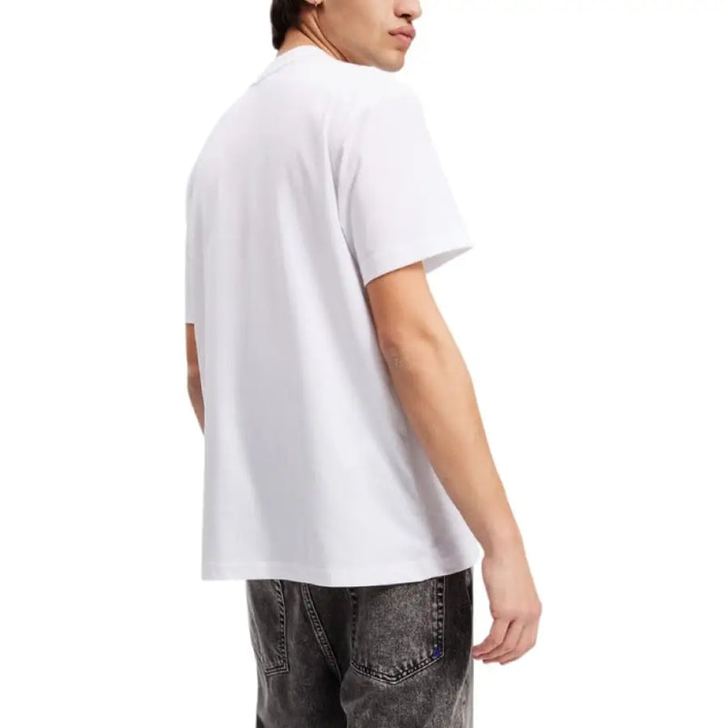 White short-sleeved T shirt featuring a black logo patch for casual style