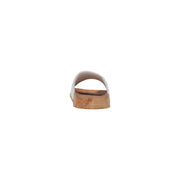 White slide sandal with cork sole and subtle embossed logo on the heel shown from the back side