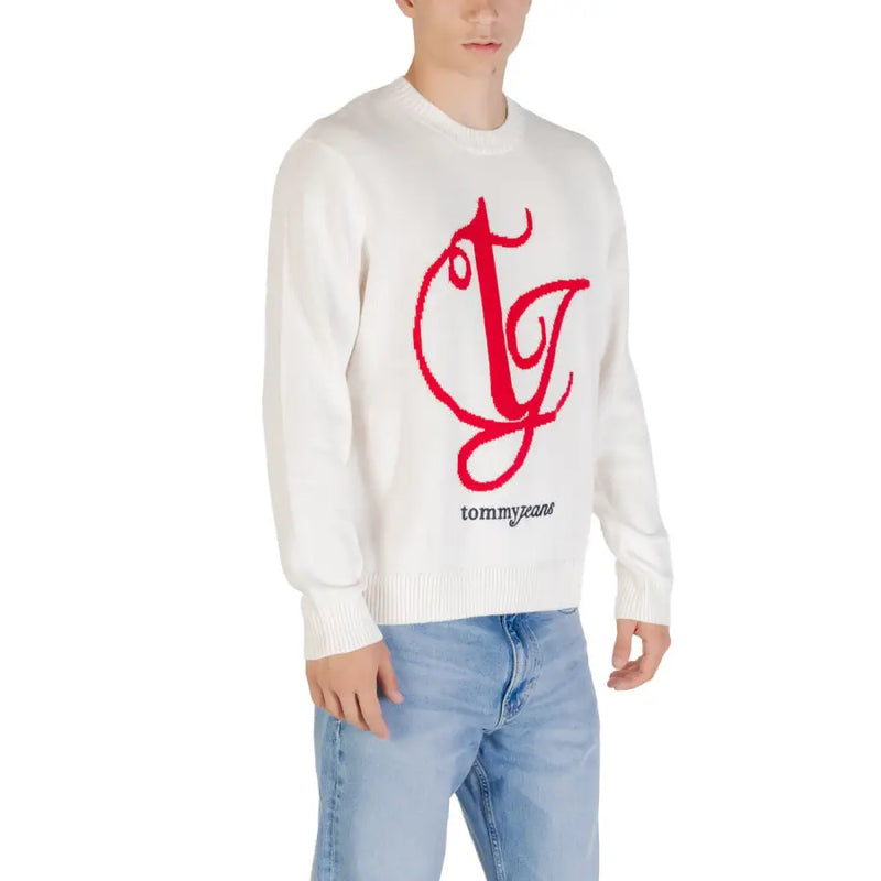 White tommy jeans sweater featuring a bold red embroidered logo with the brand name in black lettering below