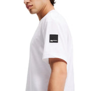 White short sleeved T shirt featuring a black logo patch on the front