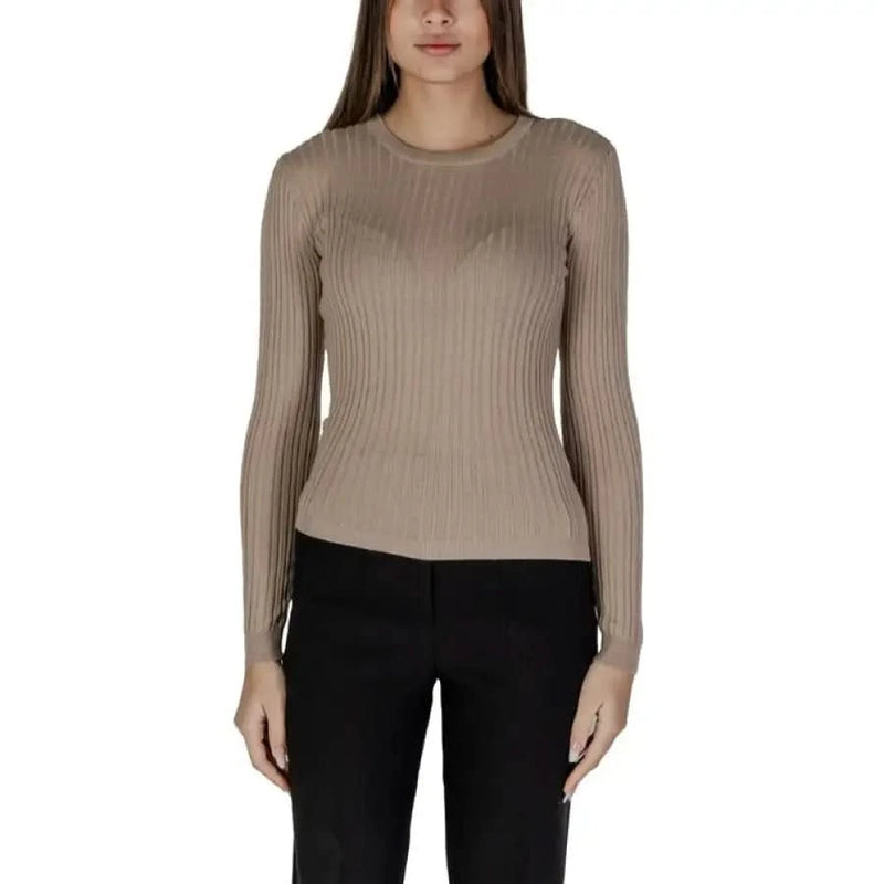 Woman in beige ribbed long-sleeve top and black pants showcasing Vila Clothes sweater