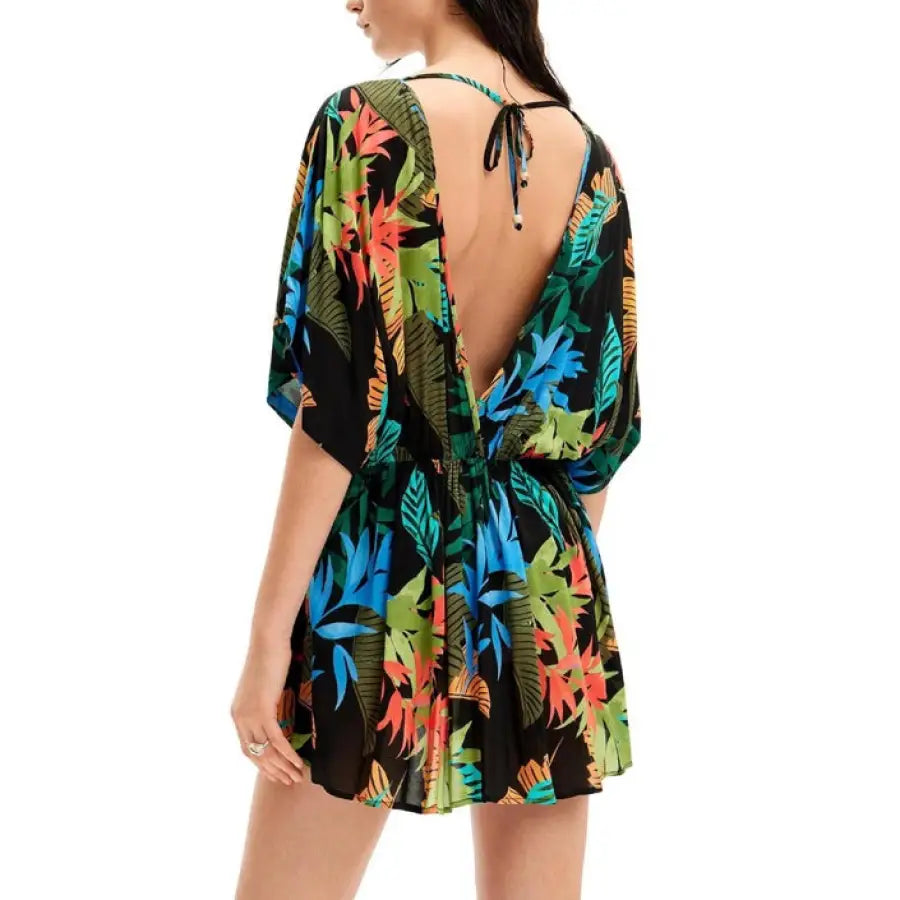 A woman in an urban-style black and green tropical print romper by Desigual