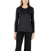 Woman wearing a black long-sleeved crew-neck top and black track pants, showcasing Armani Exchange T-shirt