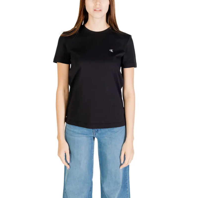 Woman wearing Calvin Klein Jeans white short sleeve round neck T shirt and light blue wide-leg jeans