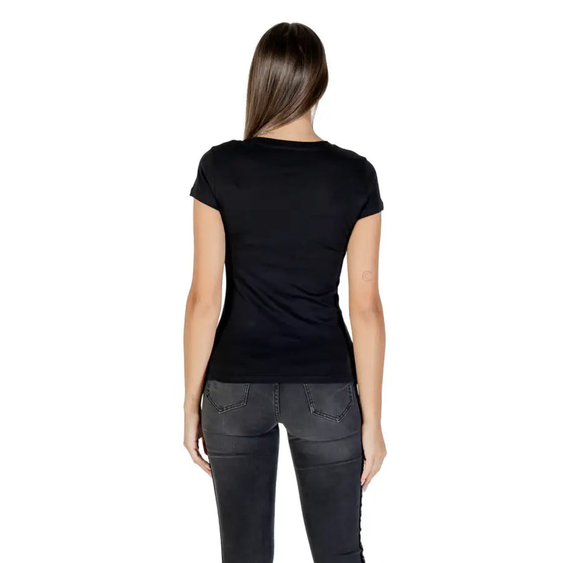 Woman wearing Armani Exchange black rhinestone print short sleeve T shirt and dark gray skinny jeans