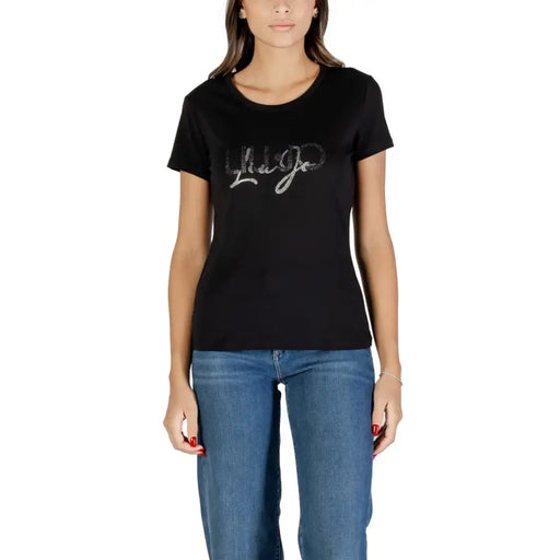 Woman wearing Liu Jo black cotton T shirt with rhinestones and blue jeans