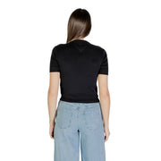 Woman wearing black organic cotton round neck T shirt and light blue wide-leg jeans