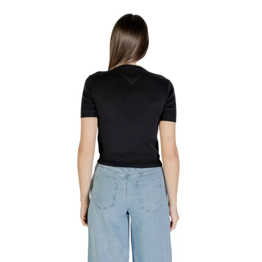 Woman wearing black organic cotton round neck T shirt and light blue wide-leg jeans