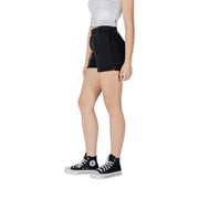 Woman wearing black Converse shorts and high-top sneakers showcasing stylish footwear