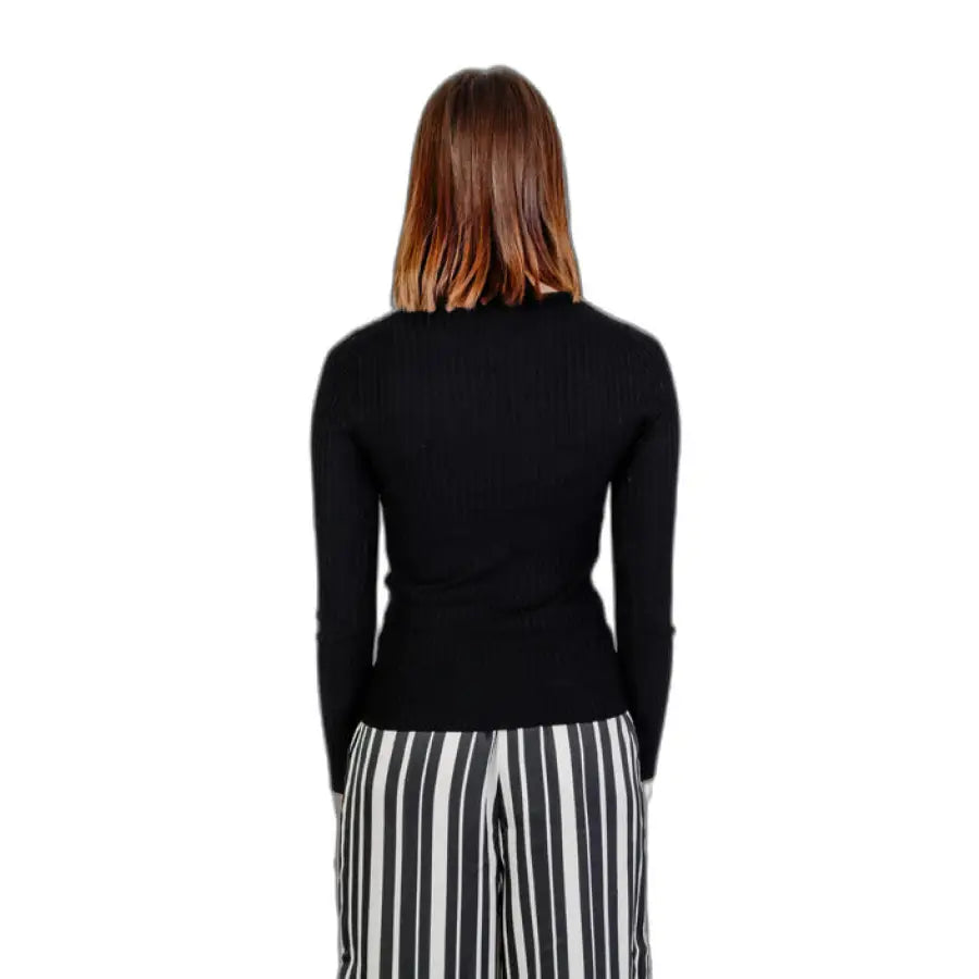 
                      
                        Woman in black sweater and striped pants from Only Women Knitwear, embodying urban city fashion
                      
                    