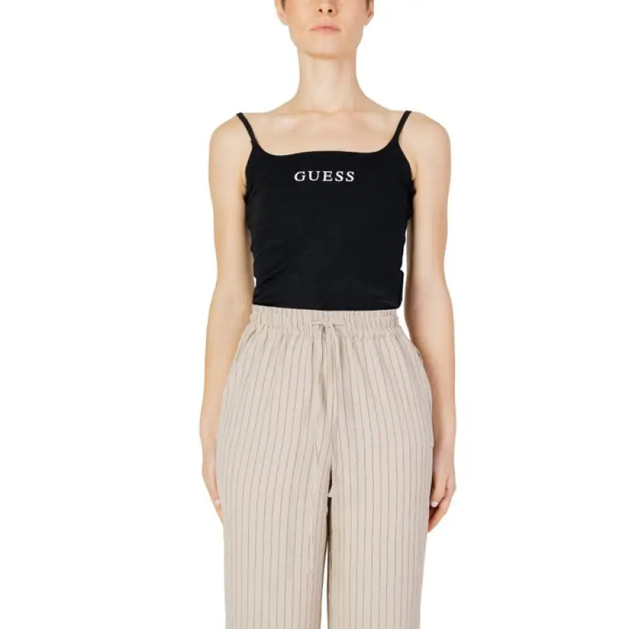 
                      
                        Woman in Guess Active tank top and beige pants
                      
                    