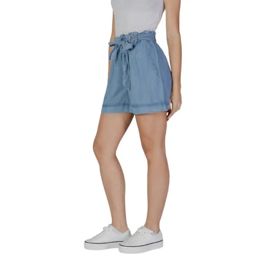 Woman wearing stylish blue paper bag waist shorts in a fashion product display