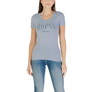 Woman wearing light blue Guess T-shirt and jeans for Fall Winter collection