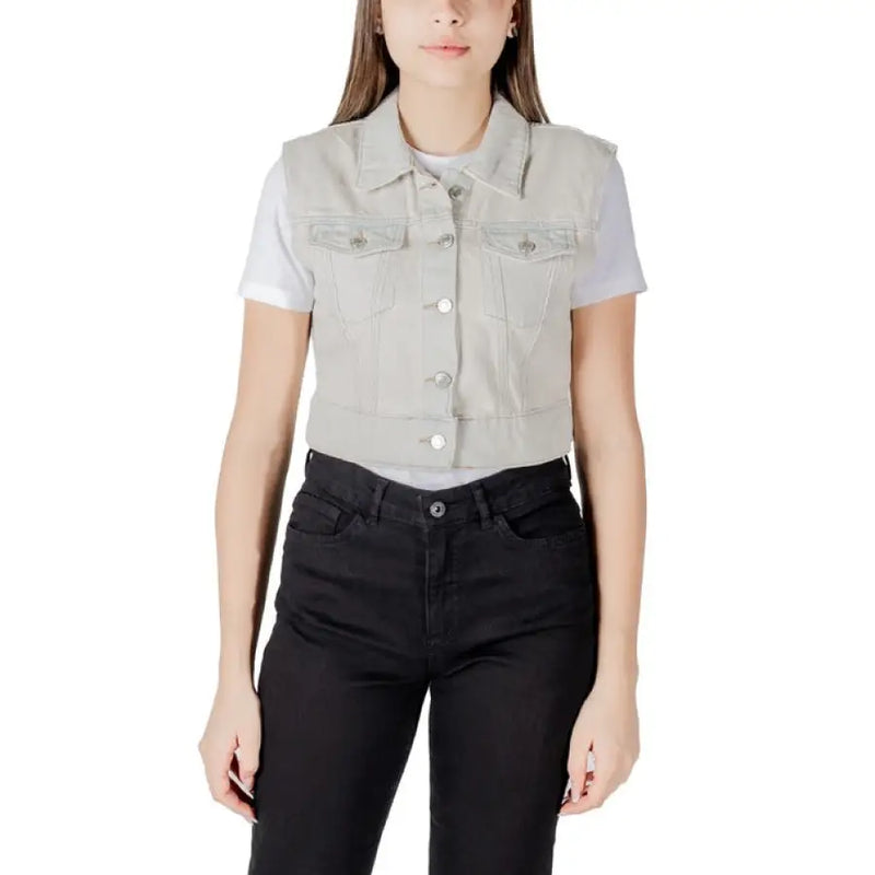 Woman wearing a light gray denim vest and black jeans showcasing the product appearance