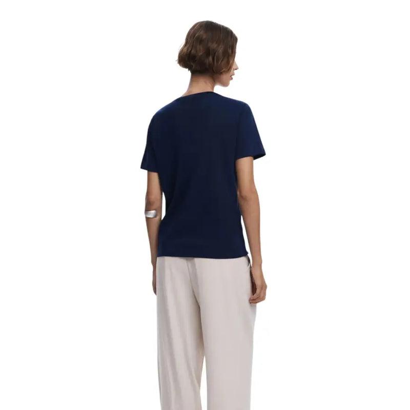 Woman wearing navy blue short-sleeve V-neck cotton T-shirt with beige wide-leg pants