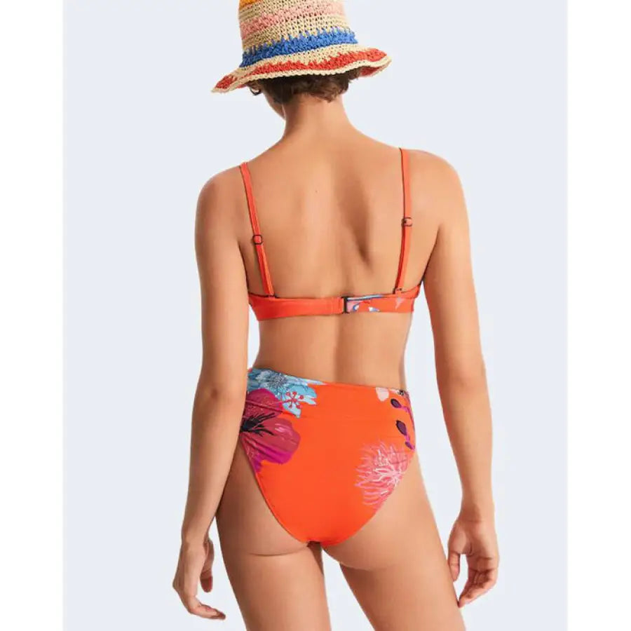 Woman in orange bikini top and straw hat showcasing Desigual women’s beachwear style