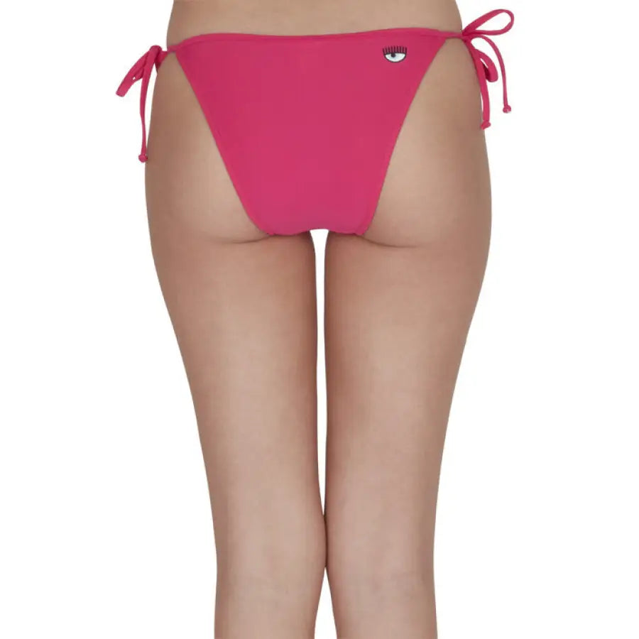 Woman in Chiara Ferragni pink bikini bottom, beachwear by Chiara Ferragni. Urban chic style