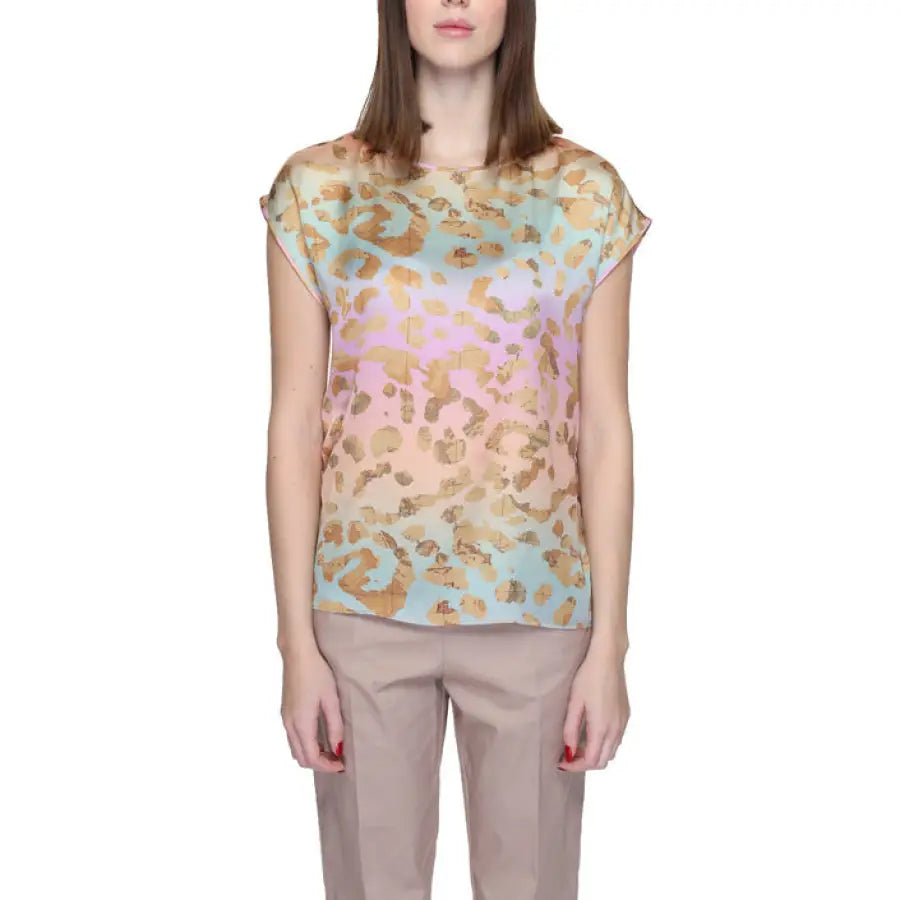 Woman in Alviero Martini Prima Classe pink and blue blouse with gold foil print