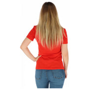Woman in red T shirt with rhinestone logo and jeans displaying the product