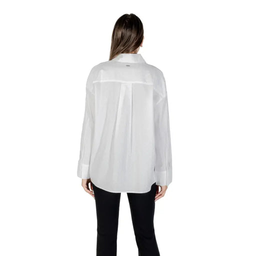 Woman wearing Armani Exchange white cotton long sleeve collared shirt and black pants