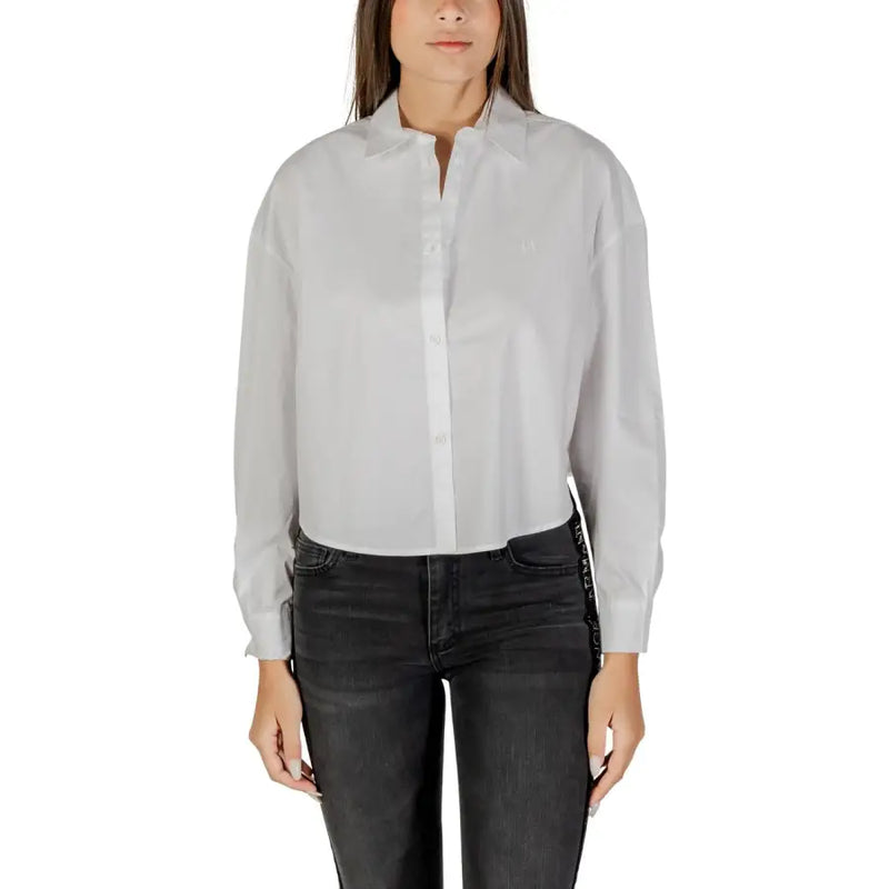 Woman wearing Armani Exchange white cotton long sleeve button shirt and dark jeans