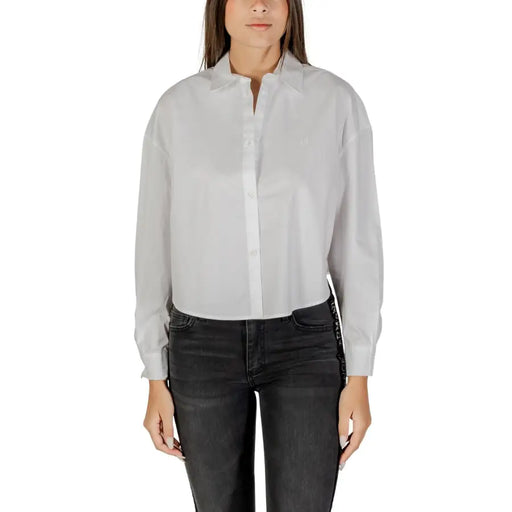 Woman wearing Armani Exchange white cotton long sleeve button shirt and dark jeans
