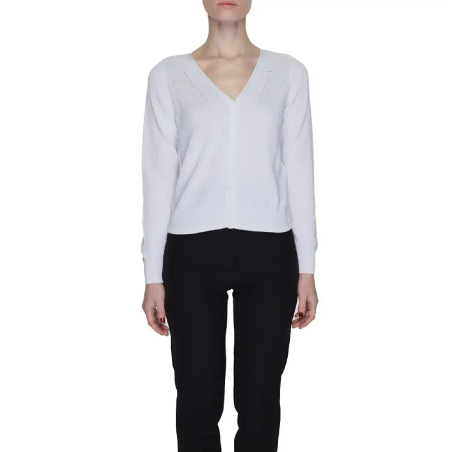 A woman in Vero Moda white shirt and black pants; urban chic fashion