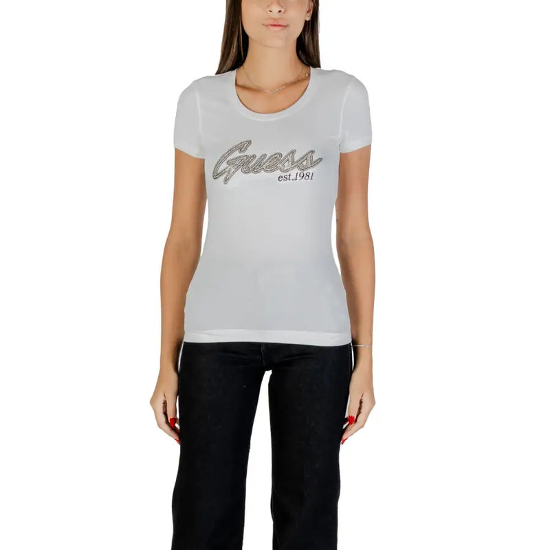 Woman wearing Guess Women White Rhinestone Round Neck Tee with graphic and black pants