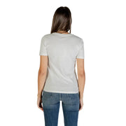 Woman in white short sleeve round neck cotton T shirt and blue jeans viewed from the back
