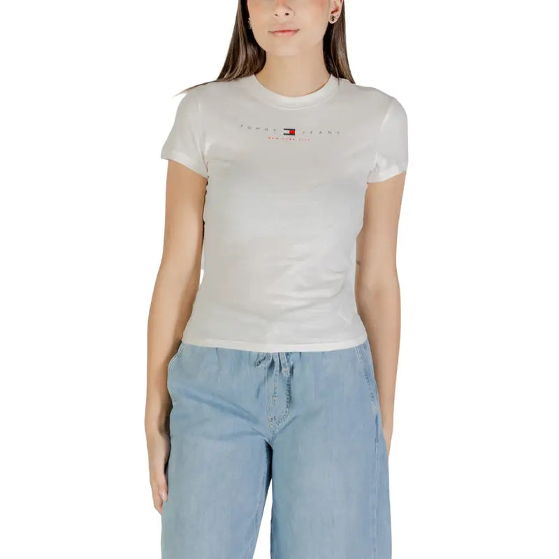 Woman wearing a white short-sleeved T-shirt and light blue wide-leg pants for Tommy Hilfiger Jeans