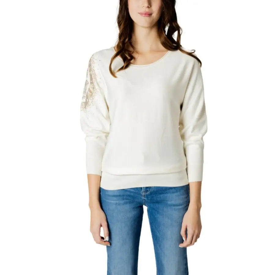 Woman in Guess women knitwear white sweater and jeans
