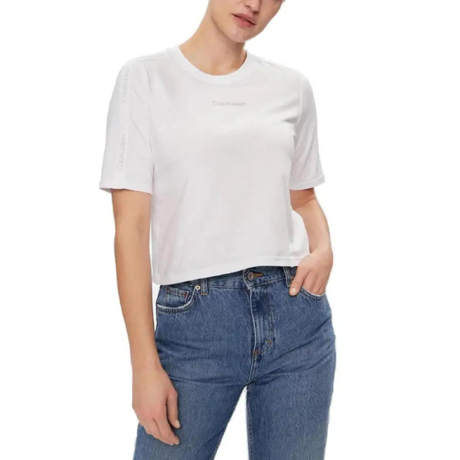 
                      
                        Woman in Calvin Klein Sport white t-shirt and jeans poses for Calvin Klein collection
                      
                    