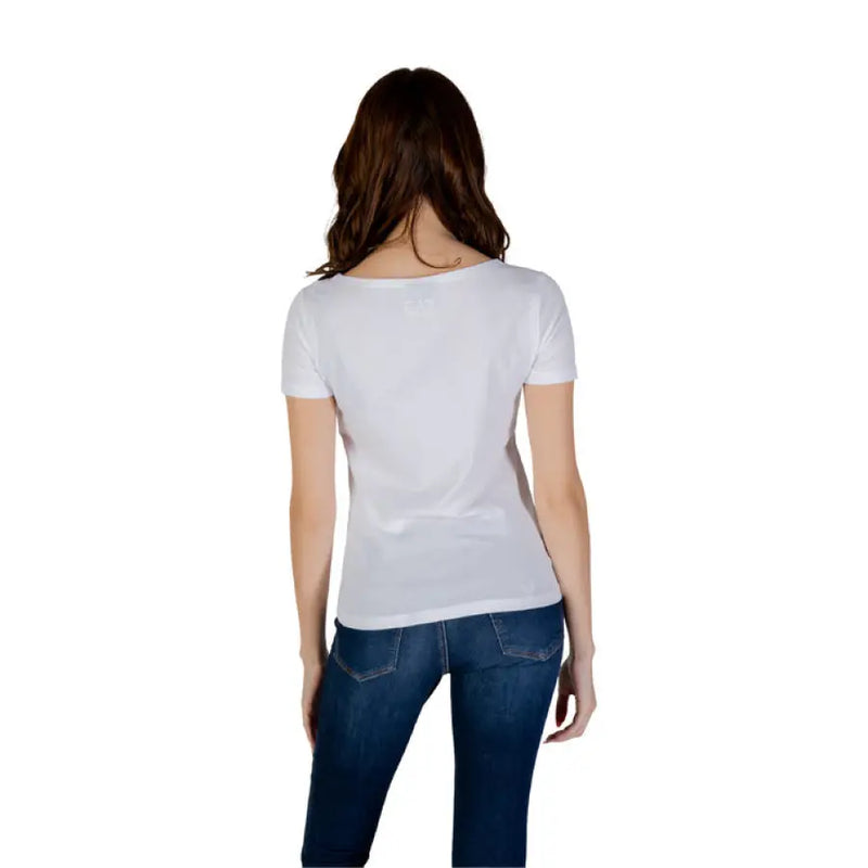 Woman wearing white short sleeved T shirt and blue jeans demonstrating casual style