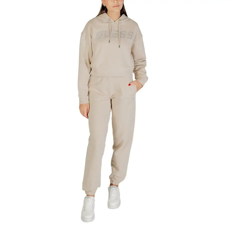 Woman wearing beige Guess Rhinestone Hooded Sweatshirt and joggers in a stylish tracksuit