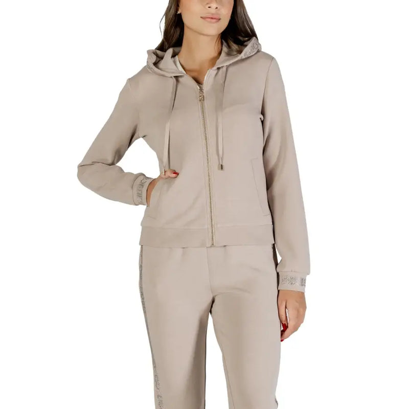 Woman wearing a beige hooded tracksuit from Liu Jo with rhinestones and a zip sweatshirt