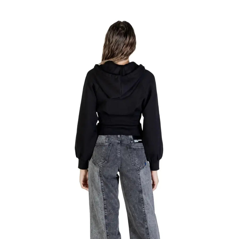 Woman wearing Armani Exchange black zip hooded sweatshirt with dark grey patchwork jeans