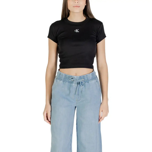 Woman wearing Calvin Klein Jeans black printed short sleeve crop top with CK logo