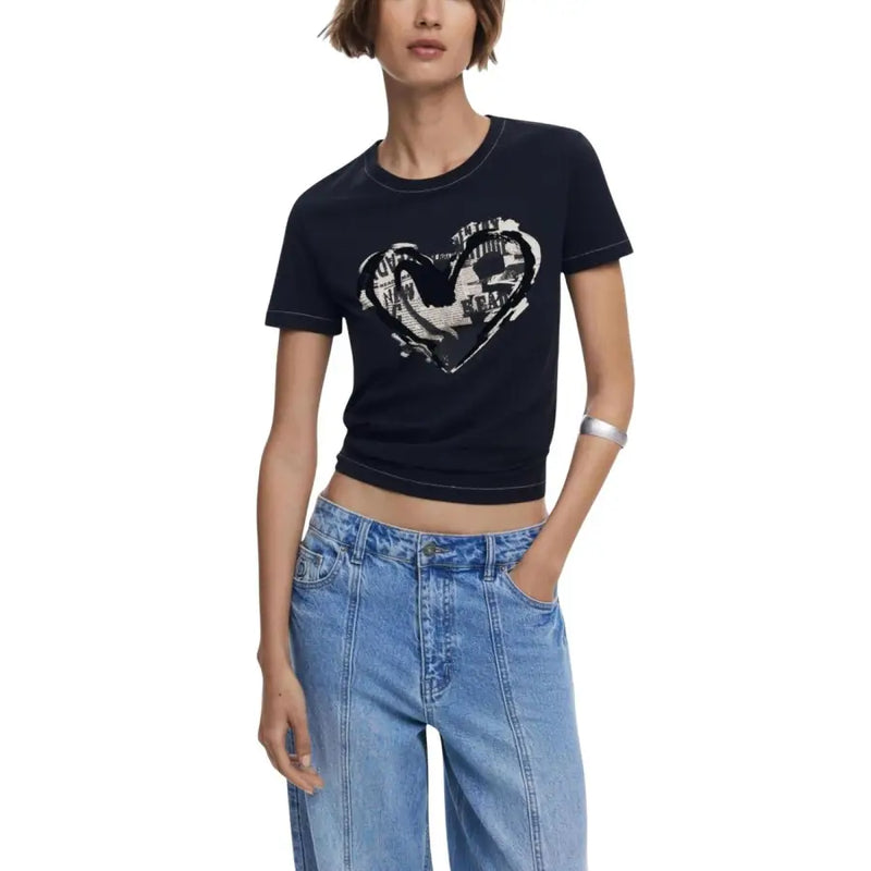Woman wearing Desigual black print short sleeve round neck T-shirt with white heart graphic and light wash jeans