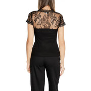 Woman wearing Morgan De Toi black V neck T shirt with sheer lace back and black trousers