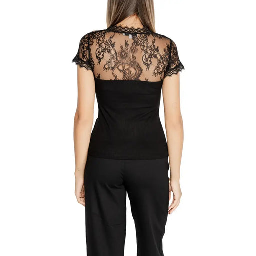 Woman wearing Morgan De Toi black V neck T shirt with sheer lace back and black trousers