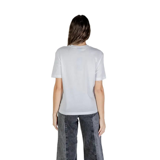 Woman wearing Karl Lagerfeld white printed round neck T shirt and grey wide-leg jeans